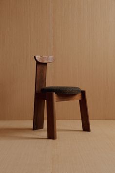 a wooden chair sitting on top of a floor next to a wood paneled wall