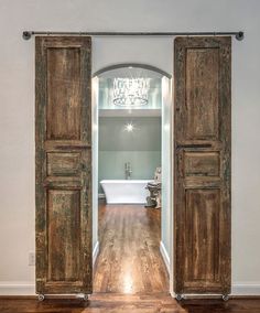 an open wooden door leading to a bathroom