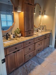 a bathroom with double sinks and large wooden cabinetry in it's center area