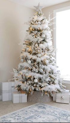 a white christmas tree with presents under it