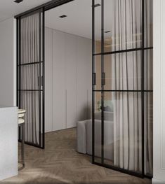 an open glass door leading to a bedroom with white walls and flooring, along with a couch