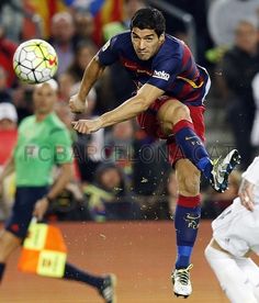 a man kicking a soccer ball on top of a field