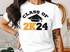 "Celebrate your milestone with our Class of 2024 graduation t-shirt! Perfect for high school or college seniors, this tee features a bold \"Class of 2K24\" design complemented by a classic graduation cap. Customize the t-shirt with your choice of colors and sizes to suit your style or create a memorable gift for that special graduate in your life. Made from soft, durable fabric, it's designed for comfort as you mark this significant achievement." Graduation Gift T-shirt With Text Print, Crew Neck, Casual Crew Neck T-shirt For Graduation Gift, Graduation Gift Short Sleeve T-shirt With Text Print, Graduation Gift Text Print T-shirt, Short Sleeve Text Print T-shirt For Graduation, White Letter Print Top For Graduation Gift, White Tops With Letter Print For Graduation Gift, School Spirit Crew Neck T-shirt For Graduation Party, School Spirit T-shirt With Text Print For Graduation