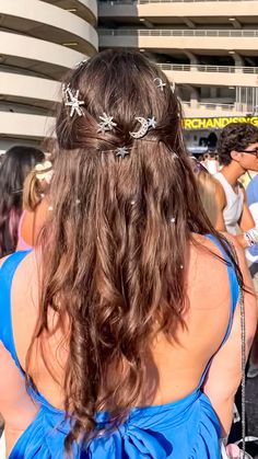 the back of a woman's head wearing a blue dress and silver hair pins