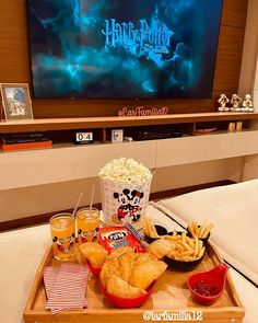 a tray that has some food on it in front of a tv with the hogwarts logo