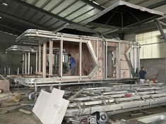 two men are working on the inside of a building that is being built with metal framing