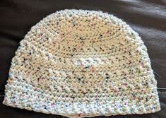 a white crocheted beanie with multicolored sprinkles on it