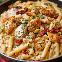 pasta with chicken, tomatoes and parmesan cheese in a pan on a table