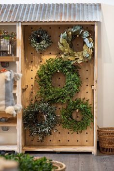 a wooden cabinet with wreaths on it