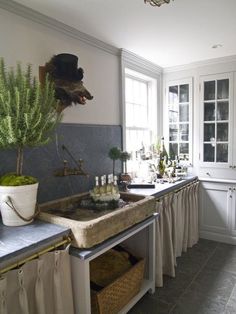 a kitchen filled with lots of counter top space next to a sink and window sill