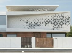 a white building with intricate designs on the side and wooden door at the entrance to it