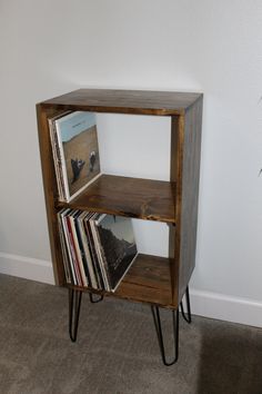 a wooden shelf with some vinyl records on it and a magazine rack next to it