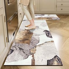 a woman standing on top of a rug in a kitchen