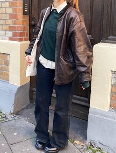 a woman standing in front of a brown door