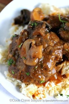 a close up of food on a plate with broccoli and meat in gravy