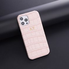 a pink iphone case sitting on top of a black surface