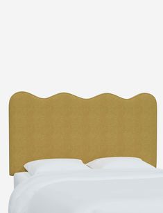 an upholstered headboard for a bed with white sheets and pillows on it