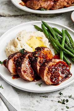 two plates with meat, mashed potatoes and green beans