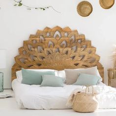 a bed with white linens and pillows in a room decorated with wicker baskets