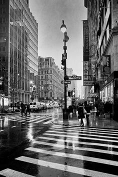 black and white photograph of people crossing the street at an intersection in new york city