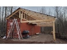 a red shed with a wooden roof and ladders to the side that is being built