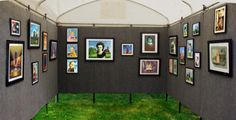 a room with pictures on the walls and grass in front of it at an art show