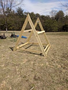 a wooden structure sitting on top of a grass covered field