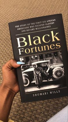 a person holding up a book about black fortunes