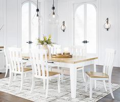 a dining room table and chairs with white walls