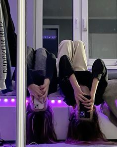 a person laying on the floor with their feet up in front of a mirror while holding a cell phone