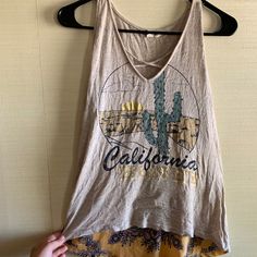 Neutral In The Front, Fun In The Back! California Honey Cactus Cross Body Tank, With Sunset And Cactus On The From And Yellow With Navy Pattern On The Bottom 3/4. A Fun Tank To Wear To The Beach, Running Errands, Or On The Golf Course! Never Worn. Casual Printed Tank Top, Casual Graphic Print Tank Top For Day Out, Casual Printed Tank Top For The Beach, Casual Printed Tank Top For Beach, Casual V-neck Tank Top For Beach Season, Summer V-neck Tank Top With Graphic Print, Country Tank Tops Women, Summer Graphic Print V-neck Tank Top, Western T-shirts & Tank Tops