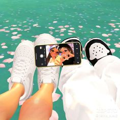 a person taking a selfie with their cell phone in front of them and flowers floating on the water