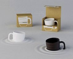 two coffee cups and one mug in a cardboard box