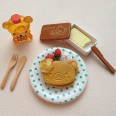 a small toy bear sitting on top of a plate