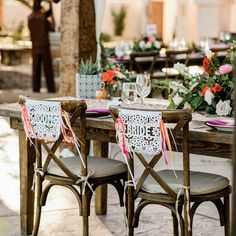 the chairs are decorated with paper cutouts and ribbons for bride and groom's names