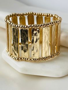 "Crafted with elegance, this finely hammered gold cuff bracelet adds a touch of unique sophistication to any ensemble. Its striking texture, curves and subtle shimmer make it a timeless piece that will endure any fashion trend. For a luxe finish to any look, this bracelet is an ideal addition including Halloween Costume Jewelry. Main Metal- 18K Plated Brass Adjustable With High Performance Double Stretch String Fits Wrist Size: 6.5\" to 8\" Shipping; Ships Next Day! Free Shipping Within US.  Pac Elegant Gold Hammered Cuff Bracelet, Gold Hammered Cuff Bracelet Bangle, Gold Metal Stretch Bracelet For Parties, Adjustable Hammered Gold Bangle, Hammered Gold Metal Bracelets, Gold Hammered Metal Bracelets, Hammered Gold Metal Bracelet, Hammered Metal Cuff Bracelet, Bracelet For Women Gold