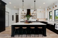 a large kitchen with an island in the middle and lots of lights hanging from the ceiling