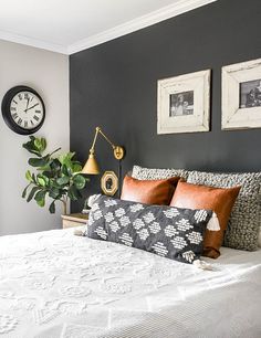 a bedroom with a large bed and two framed pictures on the wall next to it