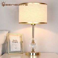 a lamp on a table next to a photo frame