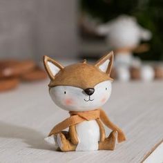 a small toy fox sitting on top of a wooden table