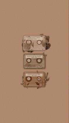 three cassettes are stacked on top of each other in front of a brown background