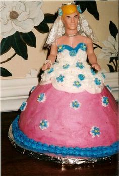 a cake shaped like a bride in a pink and blue dress