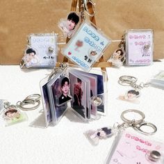 an assortment of keychains with pictures and tags attached to them sitting on a table