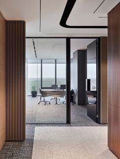 an office with wooden columns and glass walls, along with a desk in the middle