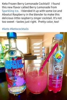 two bottles of water and a glass with pink liquid in it sitting on a table