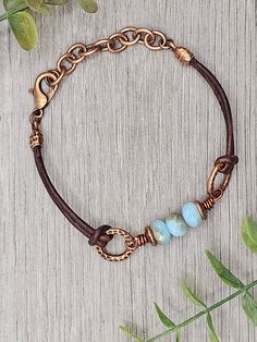 Czech Glass Aqua Opal Celsian beads with antique copper accents on antique brown leather bracelet.  This bracelet has a size fit of approximately 7 inches to 7 1/2 inches. To keep beads, leather and all other components looking their best, avoid contact with water, lotions and perfumes. To access all other items in my shop, just hit the link here: https://www.etsy.com/ca/shop/KootenayLeatherRHS If you like jewelry, check out my other Etsy shop...it's jewelry for your door!  www.etsy.com/ca/shop/ Handmade Adjustable Vintage Brown Jewelry, Patina Brown Bracelet Jewelry, Brown Patina Bracelet Jewelry, Adjustable Vintage Brown Leather Jewelry, Brown Patina Bracelet, Bohemian Brown Metal Beaded Bracelets, Adjustable Brown Leather Bracelet With Patina, Adjustable Brown Jewelry With Patina, Adjustable Brown Patina Jewelry