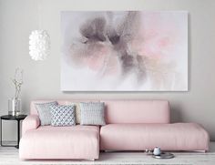 a living room with a pink couch and painting on the wall