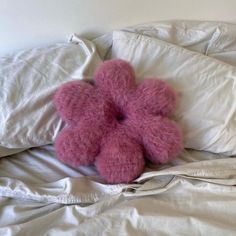 a pink teddy bear laying on top of a bed