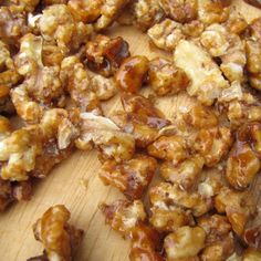 walnuts on a wooden cutting board are being chopped up into bite - size pieces