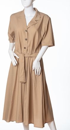 This listing is for a vintage khaki shirtdress made by Anytime For Brownstone Studio.  The dress is made from a lovely khaki material, the dress has a v-neck collar. The dress buttons in the front with wood-like buttons, to the waist.  The dress has short sleeves, 2 hip pockets, shoulder pads, a full skirt, and matching fabric tie belt. Tina the Mannequin feels so comfy in this dress! Plus, Tina wants to know if you noticed this dress has pockets!  Tina thinks pockets in dresses is genius. She thinks you're pretty genius yourself.  She also thinks it'd be genius to get this dress for yourself, because, you deserve it! Tag: Anytime for Brownstone Studio Size: vintage 12 Material: 60% Rayon 40% Polyester Khaki Collared Dress For Daywear, Beige V-neck Shirt Dress For Daywear, Collared Beige Cotton Shirt Dress, Collared Khaki Shirt Dress For Daywear, Beige Collared Midi Dress For Daywear, Vintage V-neck Midi Dress For Work, Beige Shirt Dress With Placket For Daywear, Beige Shirt Dress For Daywear, Elegant Beige Dress With Placket